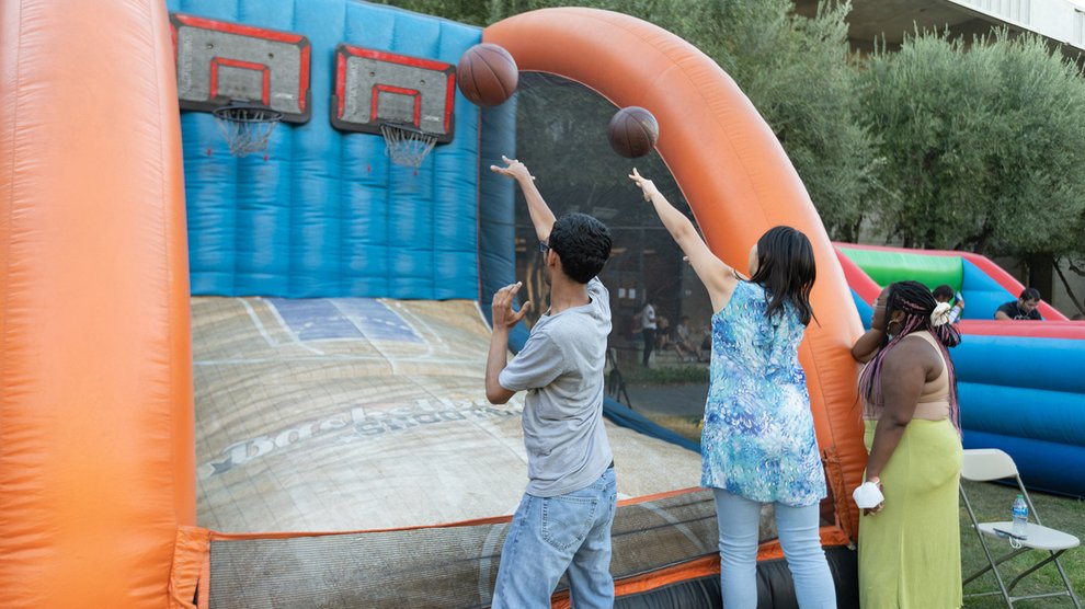Students shooting basketballs at an inflatable basketball game