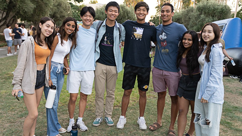 A group of eight students posing in a row