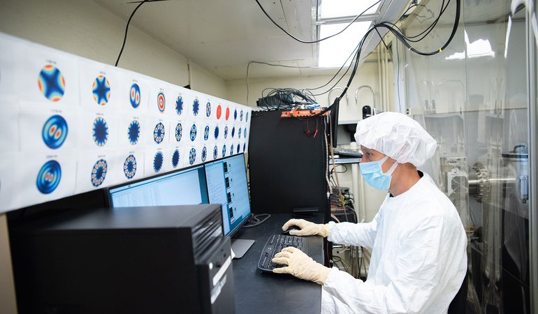 A research monitors the data from inside the chamber.