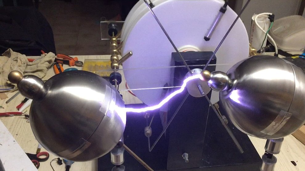 A bright and powerful spark arcs between two metal orbs.