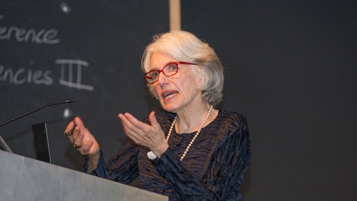 An image of Dava Sobel speaking behind a podium.