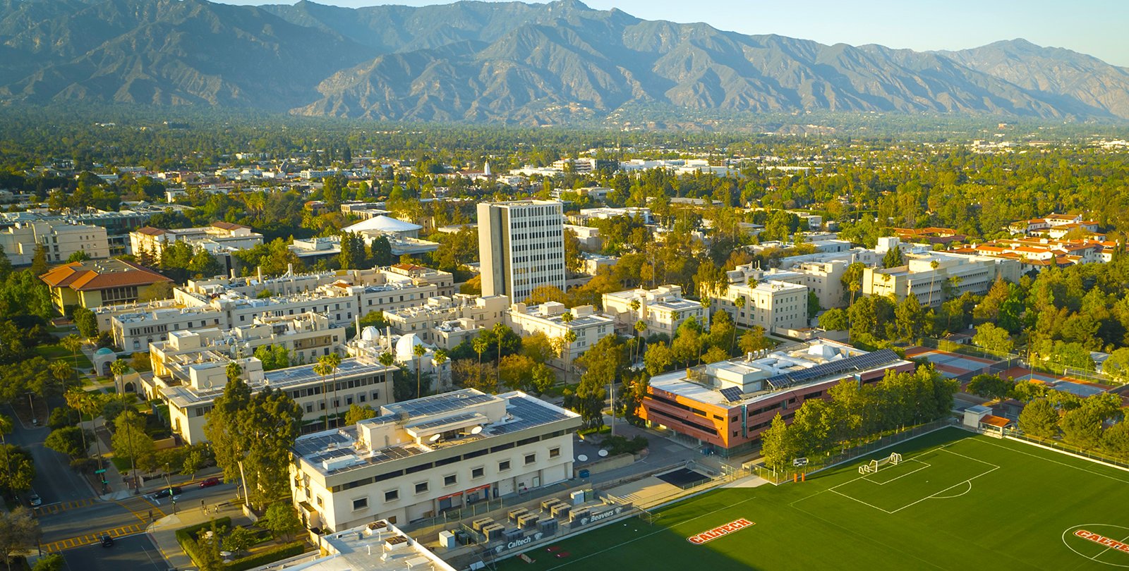 Aerial photograph of Caltech campus from just south of California Boulevard showing campus buildings and San Gabriel mountains in the background.