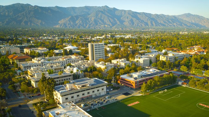 Aerial photograph of Caltech campus from just south of California Boulevard showing campus buildings and San Gabriel mountains in the background.