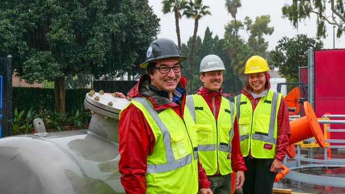 Calcarea team members Jess Adkins, Pierre Forin, and Melissa Gutierrez (BS '19) await delivery of their prototype in the rain.