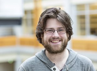Portrait of Caltech professor Adam Blank wearing glasses and a gray hooded sweartshirt