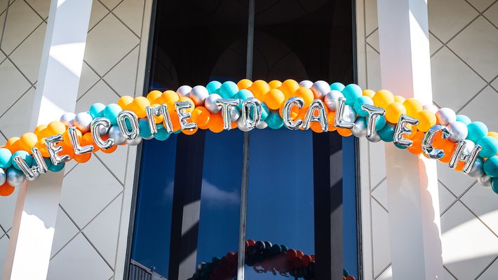 A teal and orange balloon archway with Welcome to Caltech spelled out in balloons