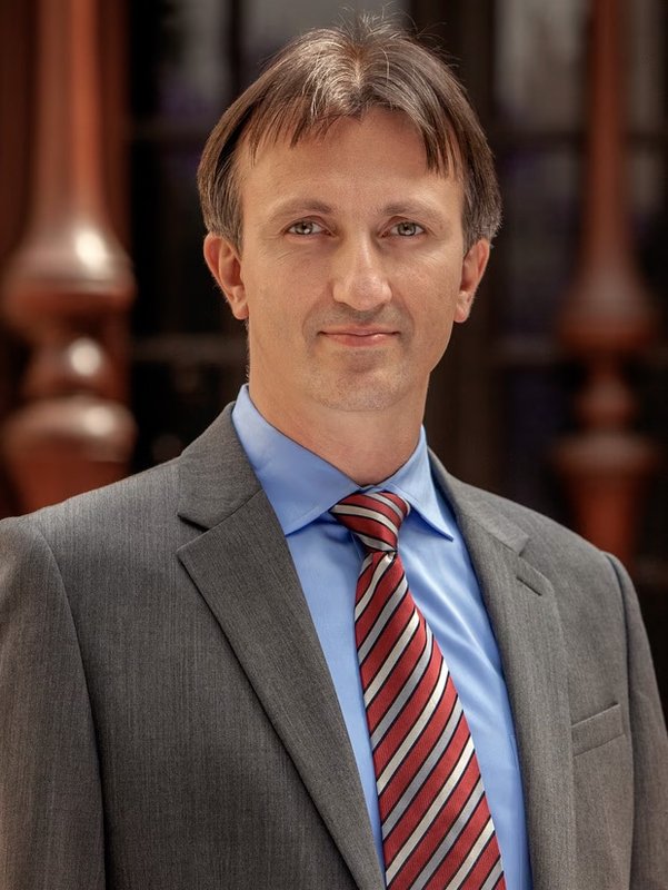 a man in a suit in front of wooden banisters 