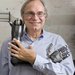Image of Richard Andersen, neuroscientist, holding a robotic arm