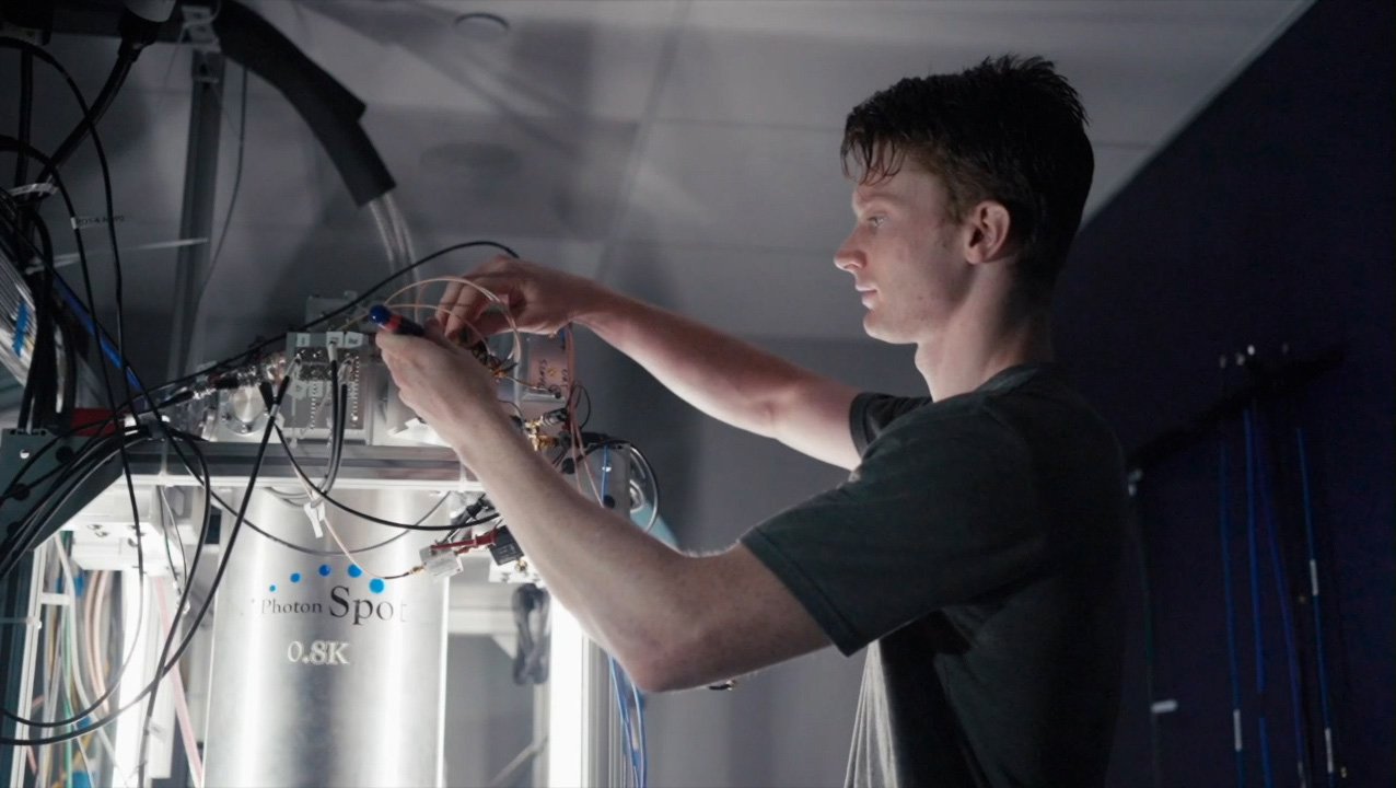 Caltech graduate student Andrew Mueller adjusting the cryogenic equipment where the CQNET quantum detectors are housed