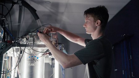 Caltech graduate student Andrew Mueller adjusting the cryogenic equipment where the CQNET quantum detectors are housed