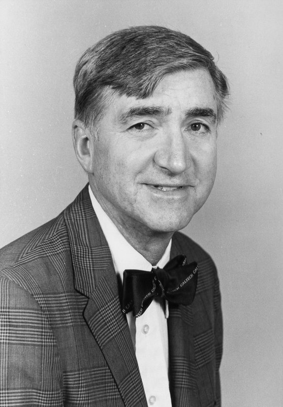 A black and white photo of a man with a bowtie