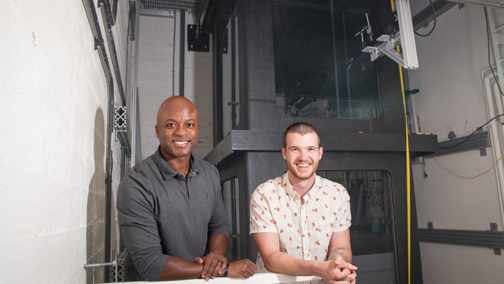 John Dabiri, left, with Simon Anuszczyk, standing in front of their 20-foot-tall tank of water.
