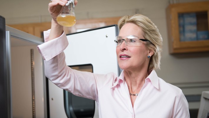 Frances Arnold looks into a chemical flask.