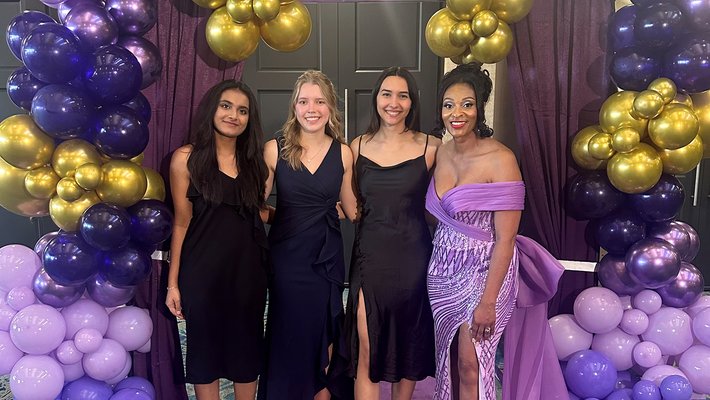 Caltech student tutors (left to right) Tisya Rawat, Miina Anvelt, and Gabi Twombly join SGV-NCNW President Marie Thermidor (right), surrounded by a purple and gold balloon arrangement