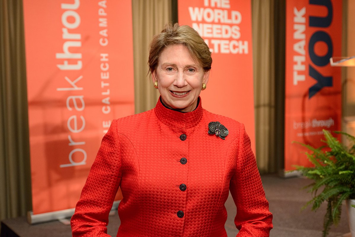 Cropped photo of woman standing in front of orange banners