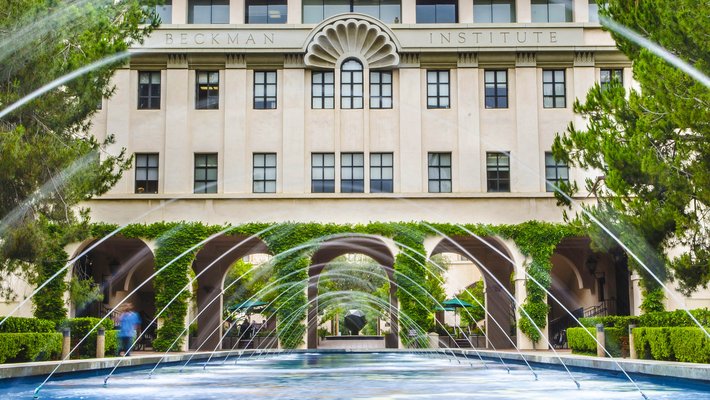 a fountain shooting arcs of water in front of the Beckman Institute building and courtyard