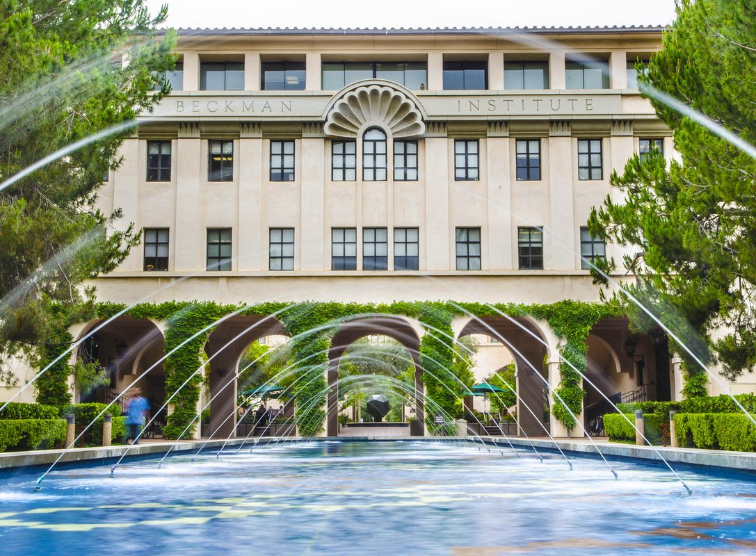 a fountain shooting arcs of water in front of the Beckman Institute building and courtyard
