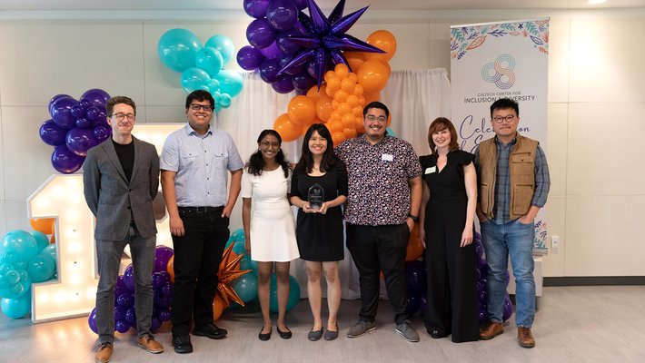 A group of seven people smiling into the camera