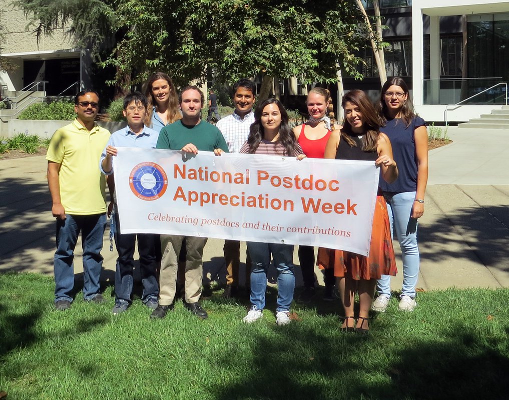 members of the Caltech Postdoc Association hold a banner for Postdoc Appreciation Week.