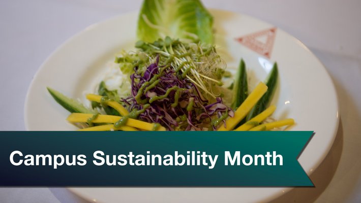 A salad on a white ceramic plate, with a green ribbon saying "Campus Sustainability Month"