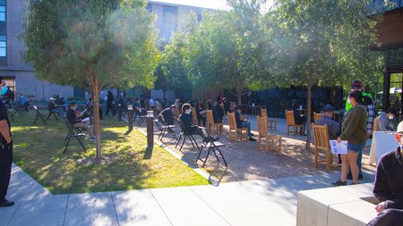 People in courtyard gather for their shots
