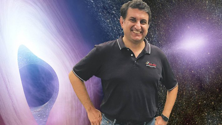 Varoujan Gorjian standing in front of an artist's rendering of the gaseous accretion disk of an active galactic nucleus