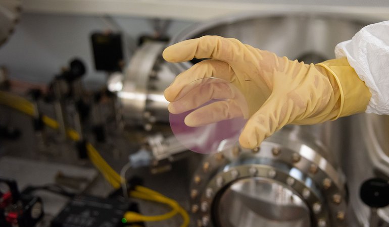 A pinkish coating on a test mirror disk.