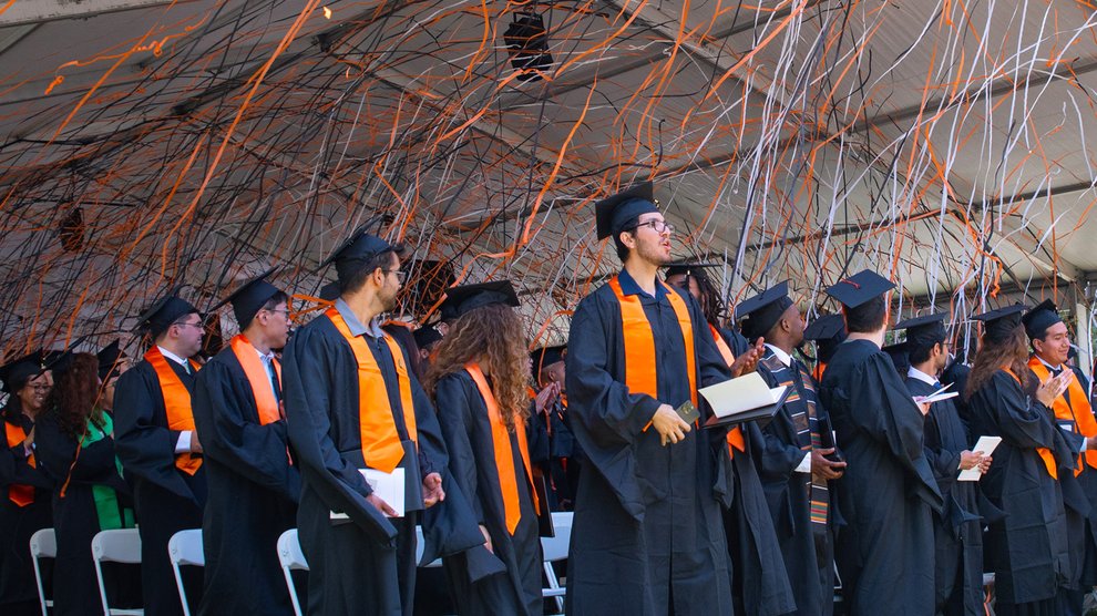 Orange, black, and white confetti falls on Caltech's newest graduates who are wearing their caps and gowns