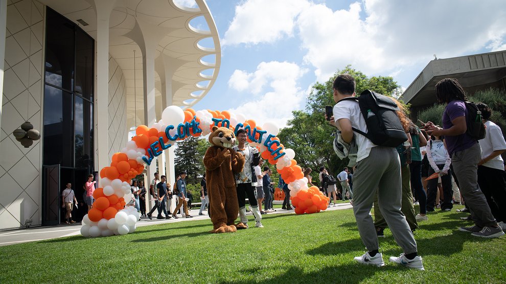 Students pose for photos with Berni the Beaver after Convocation