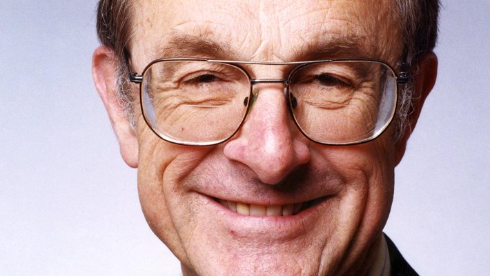 A portrait of Fred Culick. He wears glasses, a shirt, tie, and jacket.