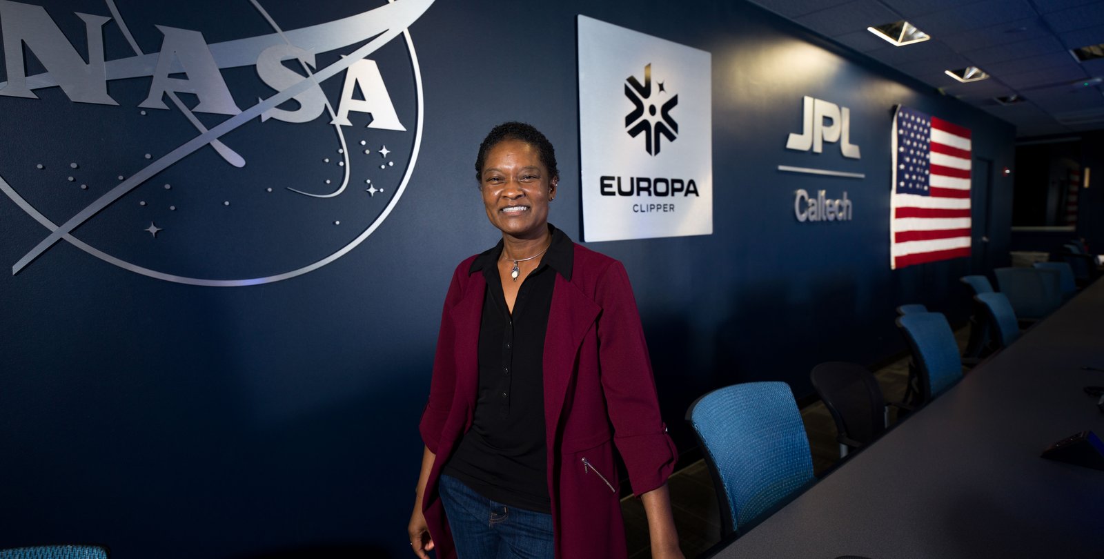 Image of Tracy Drain in front of a wall that reads NASA JPL Caltech