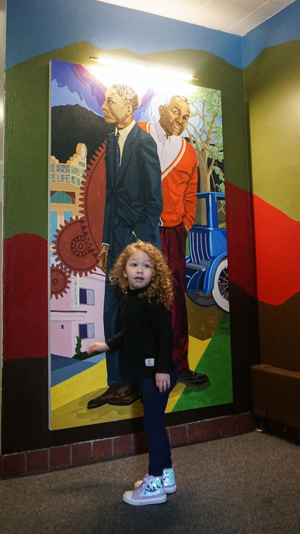 Stella Stinchcomb stands in front of the portrait of her great-grandfather, Grant D. Venerable.