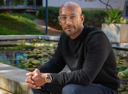 Sujit Datta sitting on the edge of the lily pond at Caltech