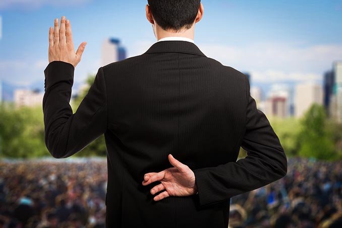 man in suit with fingers crossed behind his back