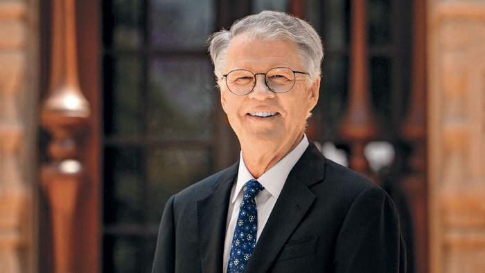 A portrait of Peter Dervan. He wears a suit and tie and smiles at the camera.