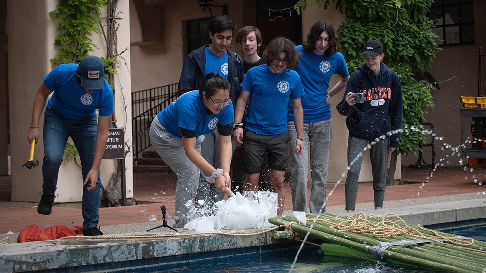 Members of "Avatar: The Last Stack" smash open an ice block using hammers.