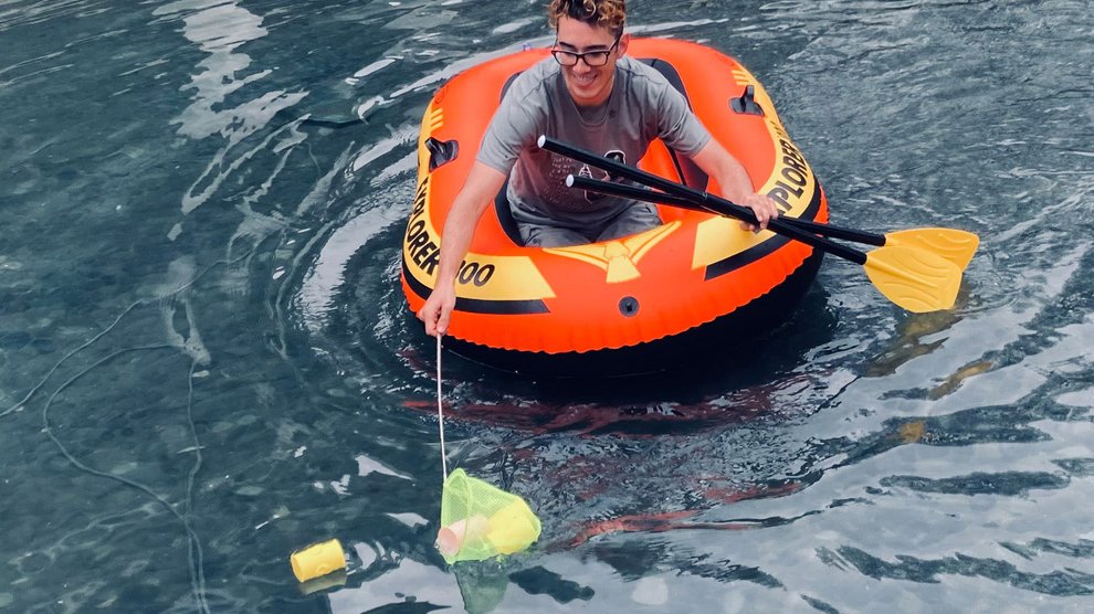 Undergraduate Michael Gutierrez fishes for clues in the Caltech Hall Pond.
