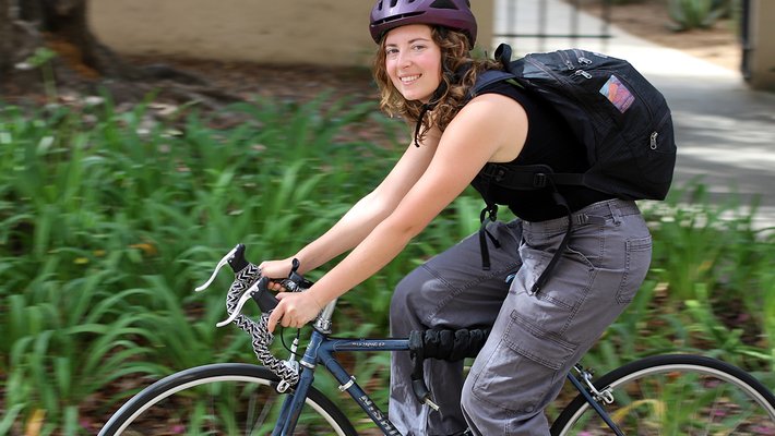 Elina Sendonaris riding her bike on campus