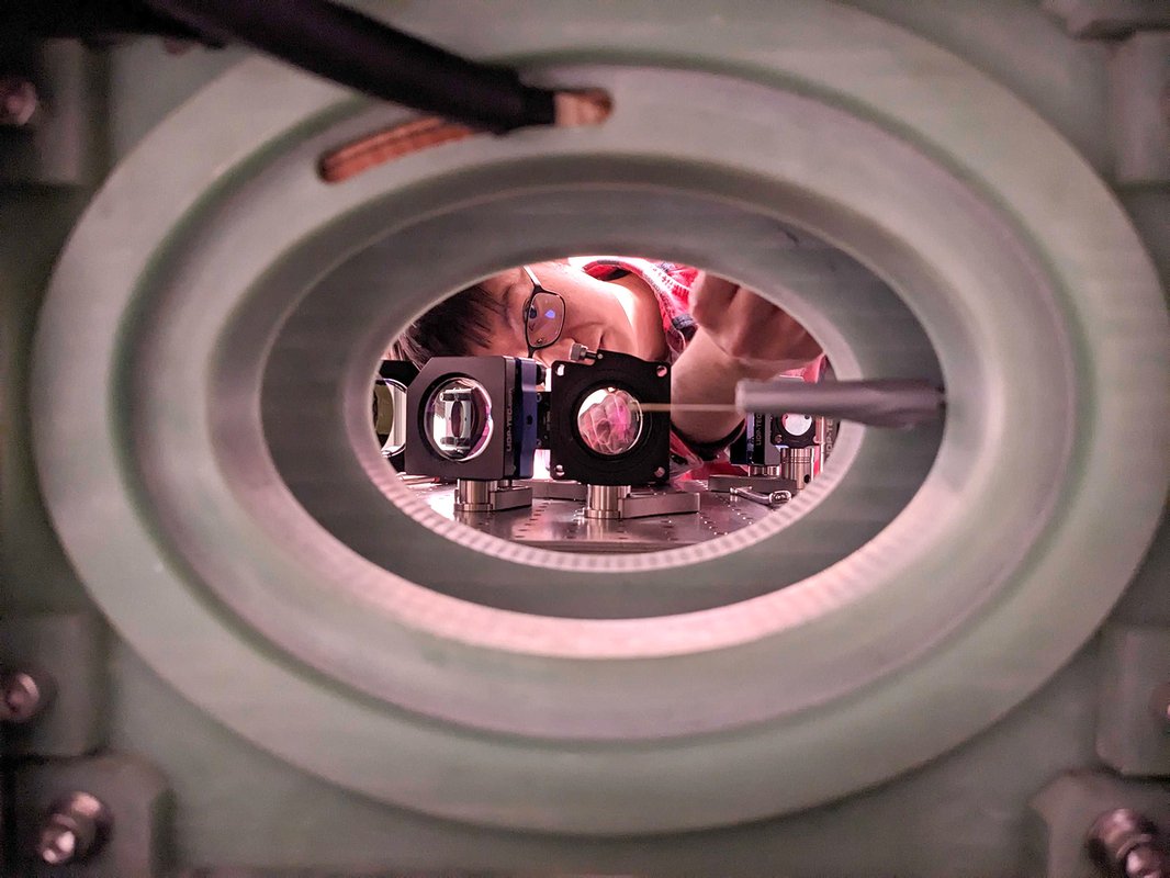 Researcher peers into an optical bench.