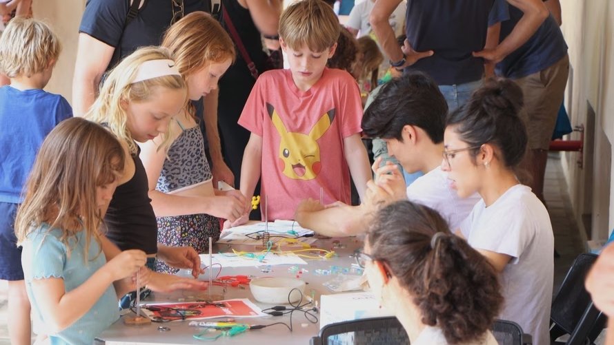 People gather around a tabletop activity
