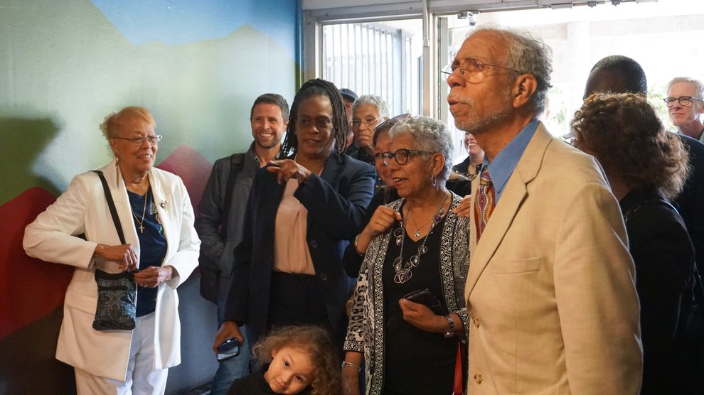 Grant D. Venerable II, first from right, and Lynda Venerable Ellington, second from right, get a first glimpse of the painting with other family and community members.