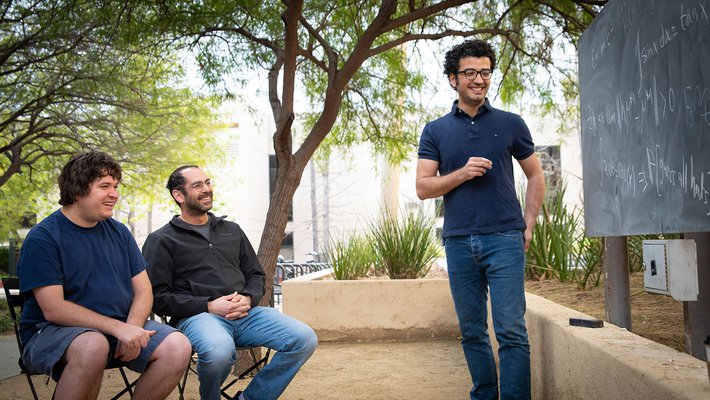 Joshua Frisch, Omer Tamuz, and Pooya Vahidi Ferdowsi discuss a math problem at Caltech.