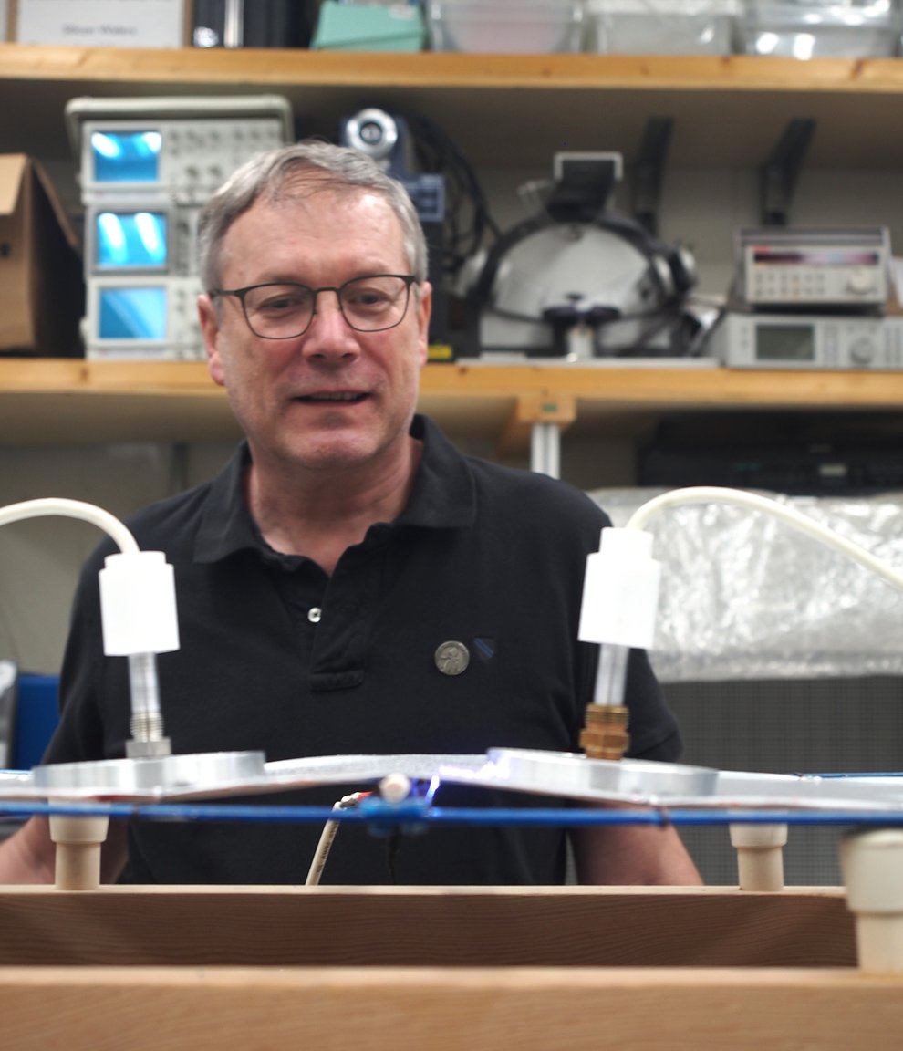 A photo of Konstantinos Giapis as he examines the model of the Hindenburg's skin and frame and waits to see if a spark will form.