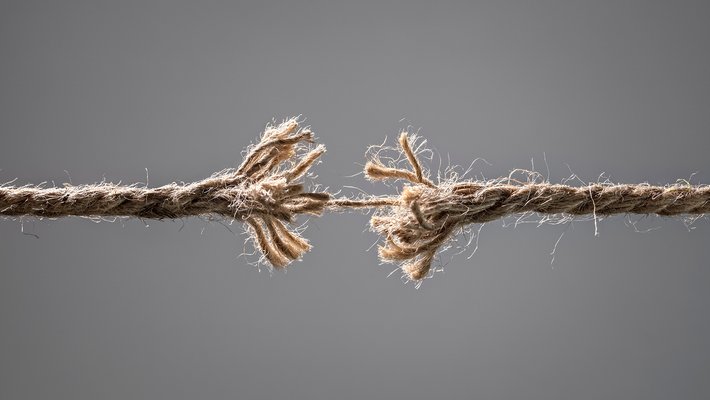 A frayed rope is shown about to be torn in half in the middle