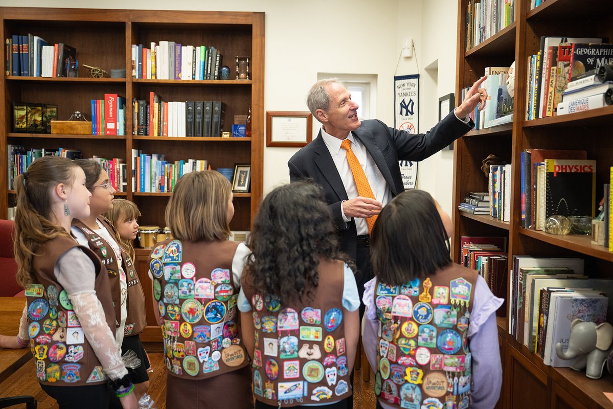 Caltech President Thomas Rosenbaum shows six visiting Girl Scout Brownies a basketball signed by eight Nobel laureates