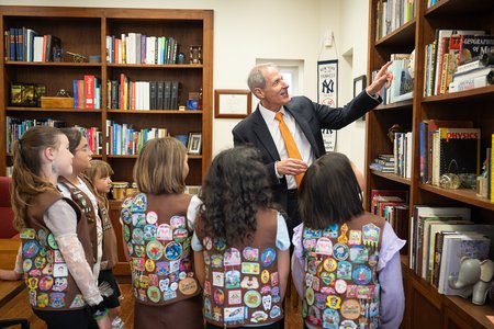 Caltech President Thomas Rosenbaum shows six visiting Girl Scout Brownies a basketball signed by eight Nobel laureates