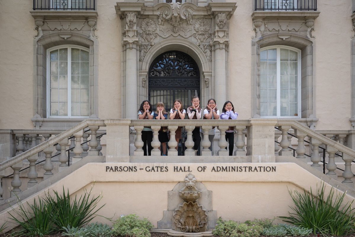 Six Girl Scout Brownies smile at the entrance to Caltech's Parsons-Gates Hall of Administration