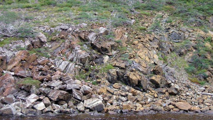 A field of rocks and boulders at the edge of a stream