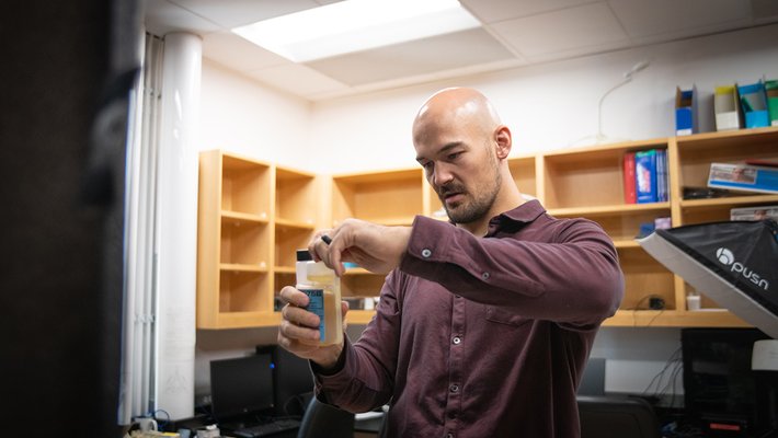 Person putting a cap on a container of liquid