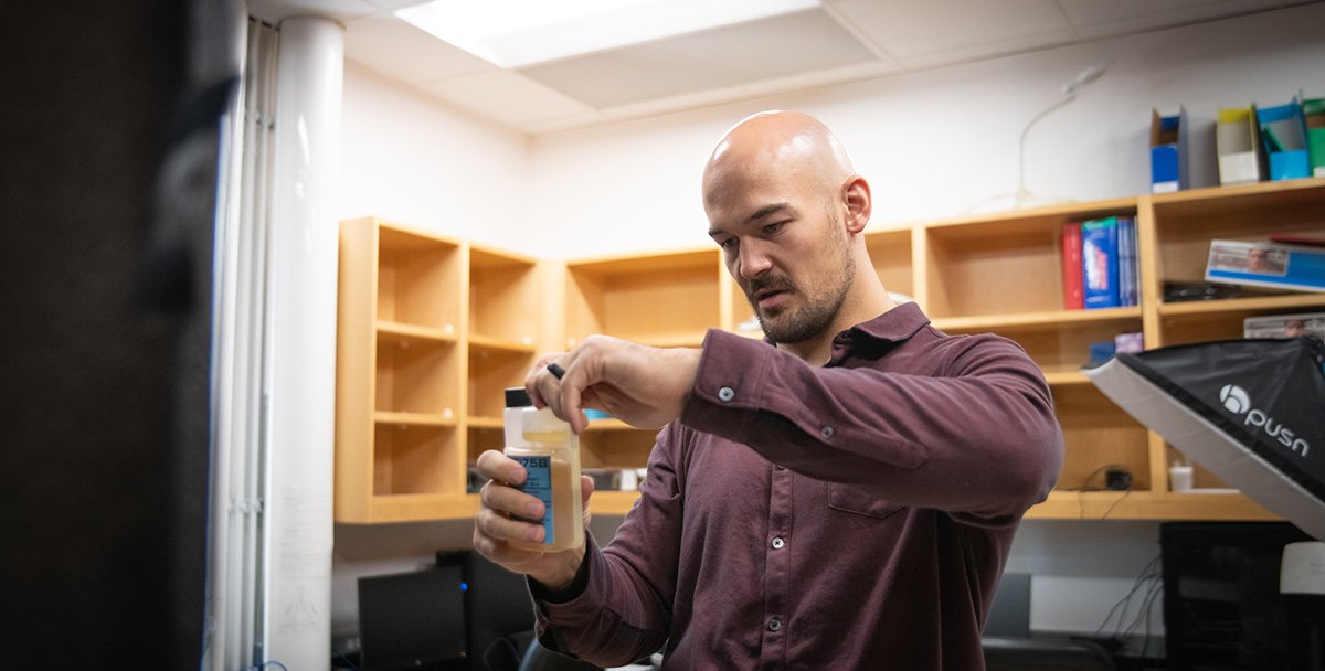 Person putting a cap on a container of liquid